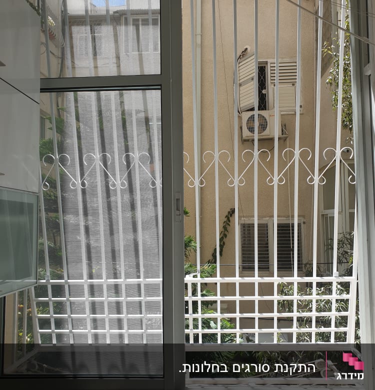 חלון עם סורגים לבנים ודלת זכוכית שקופה